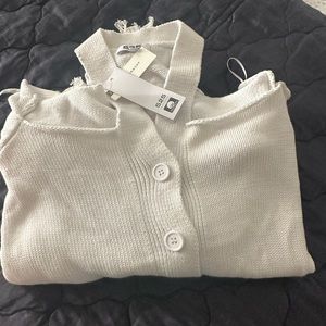 Cold shoulder white sweater with distressed sleeves and hem. New with Tags